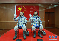 航天员景海鹏（左）、陈冬在出征前挥手
